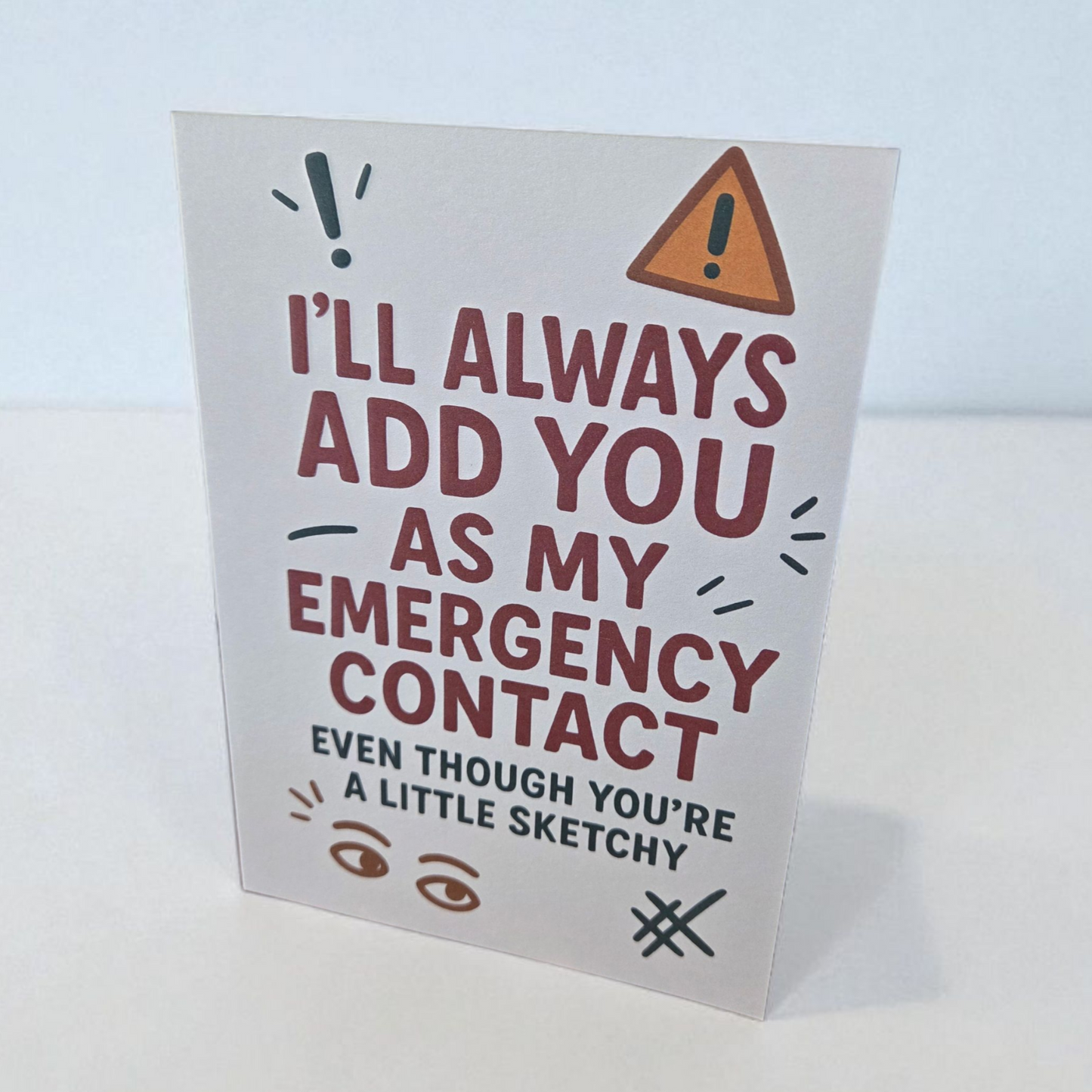Greeting card reading ‘I’ll Always Add You As My Emergency Contact Even Though You’re A Little Sketchy’ with playful icons.