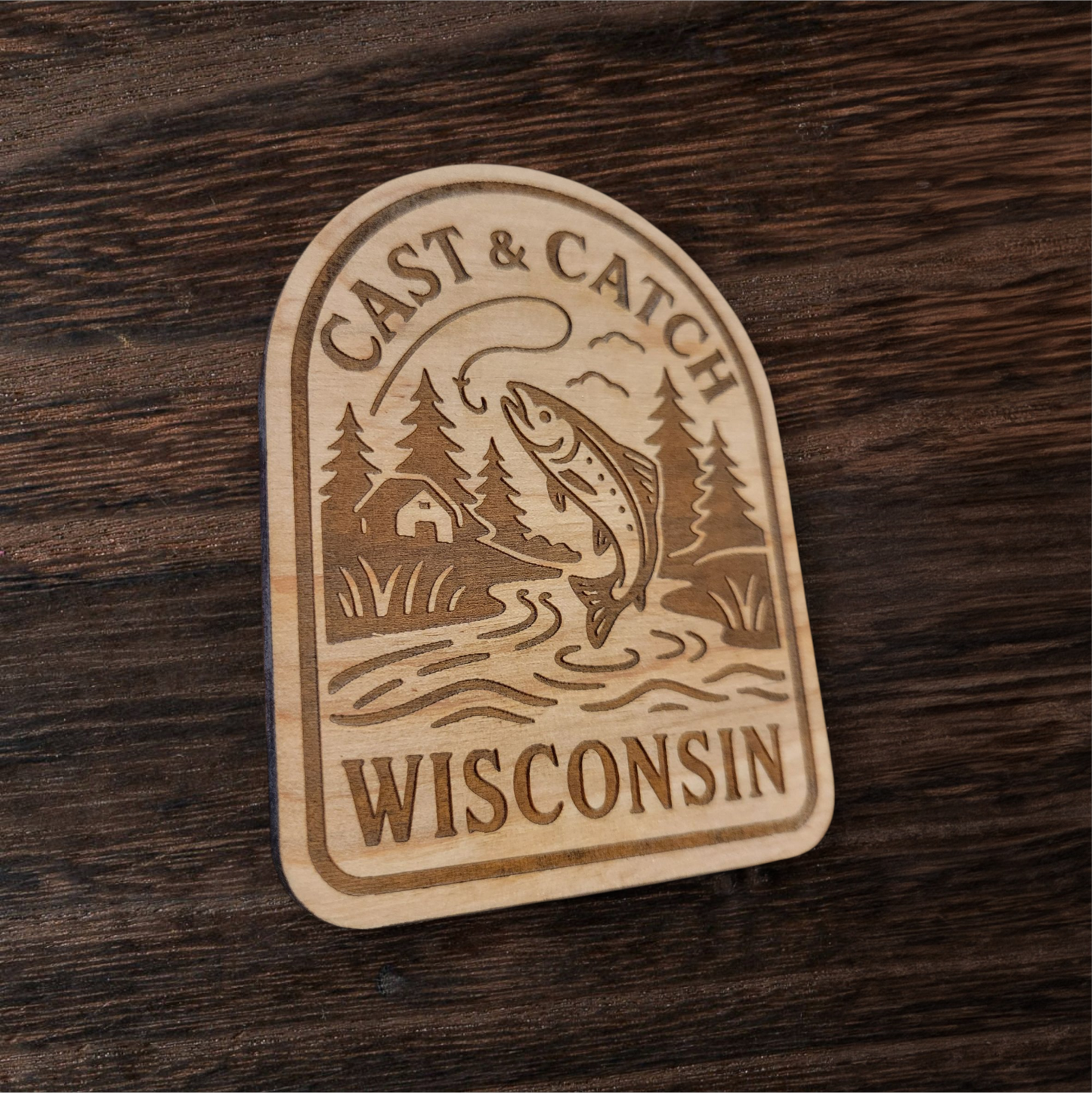 Laser engraved fishing magnet featuring a trout and cabin scene – Cast & Catch Wisconsin rustic wood design