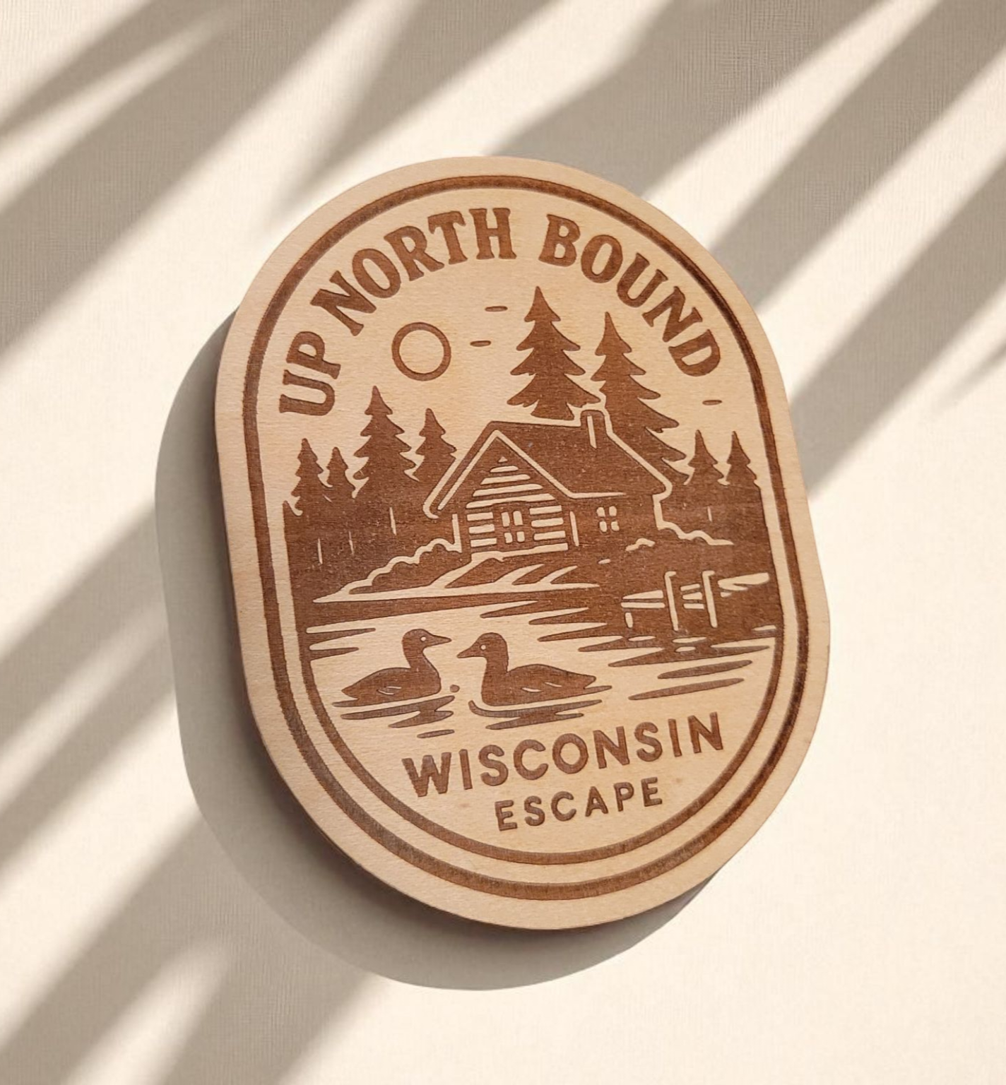 Wood magnet engraved with a lakeside cabin, pine trees, loons, and the words “Up North Bound – Wisconsin Escape.”