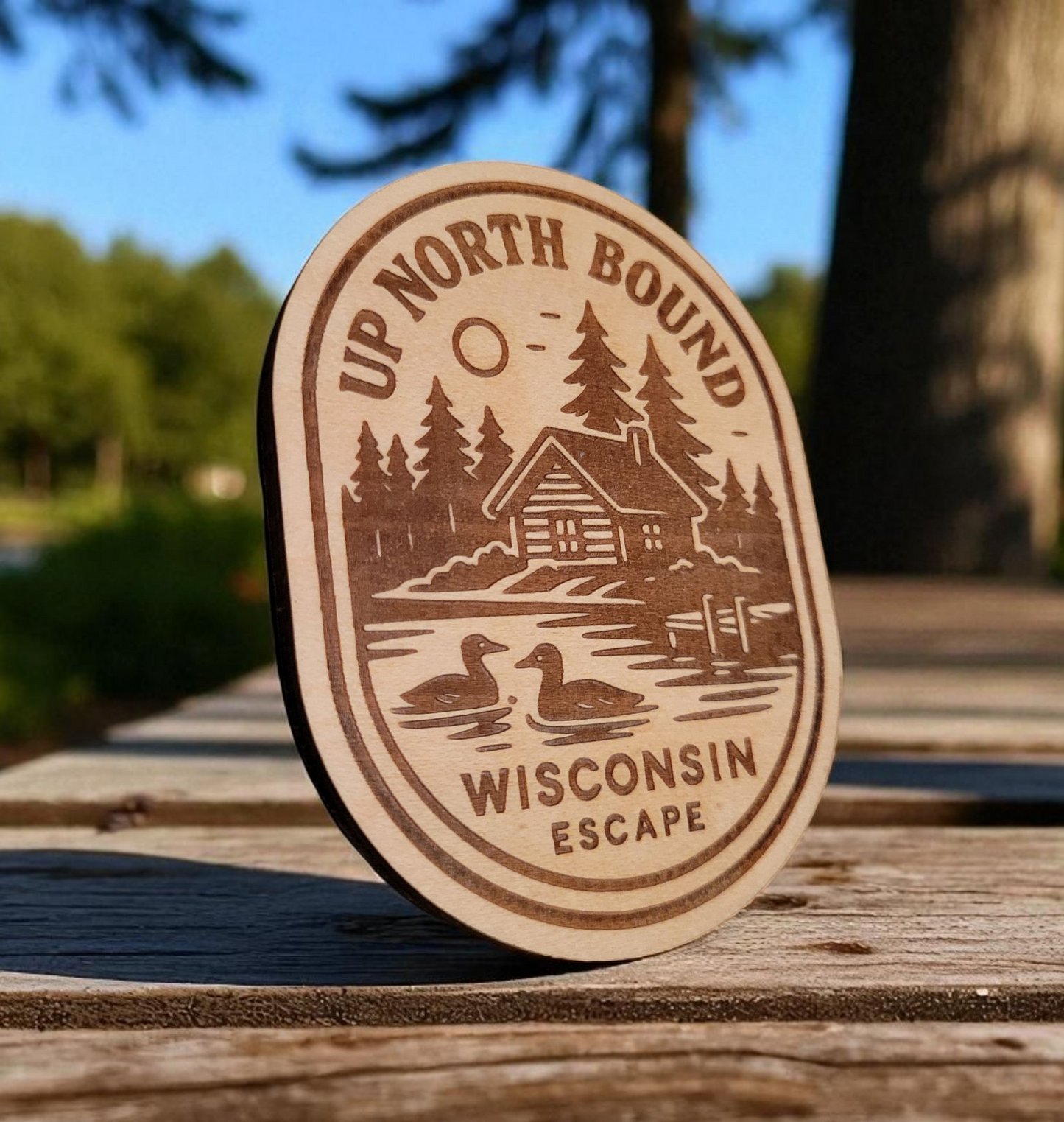 Wood magnet engraved with a lakeside cabin, pine trees, loons, and the words “Up North Bound – Wisconsin Escape.”