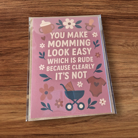 Greeting card reading ‘You make momming look easy which is rude because clearly it’s not’ with pink background and floral accents.