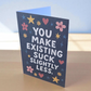 Greeting card reading ‘You Make Existing Suck Slightly Less’ with stars and floral illustrations.