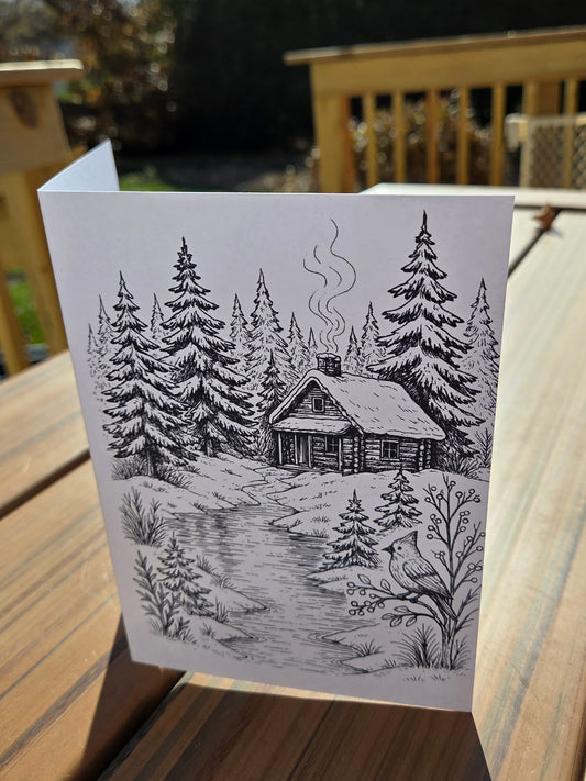 Winter cabin line-art card printed on watercolor paper, designed for painting or coloring.