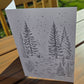 Winter cabin line-art card printed on watercolor paper, designed for painting or coloring.