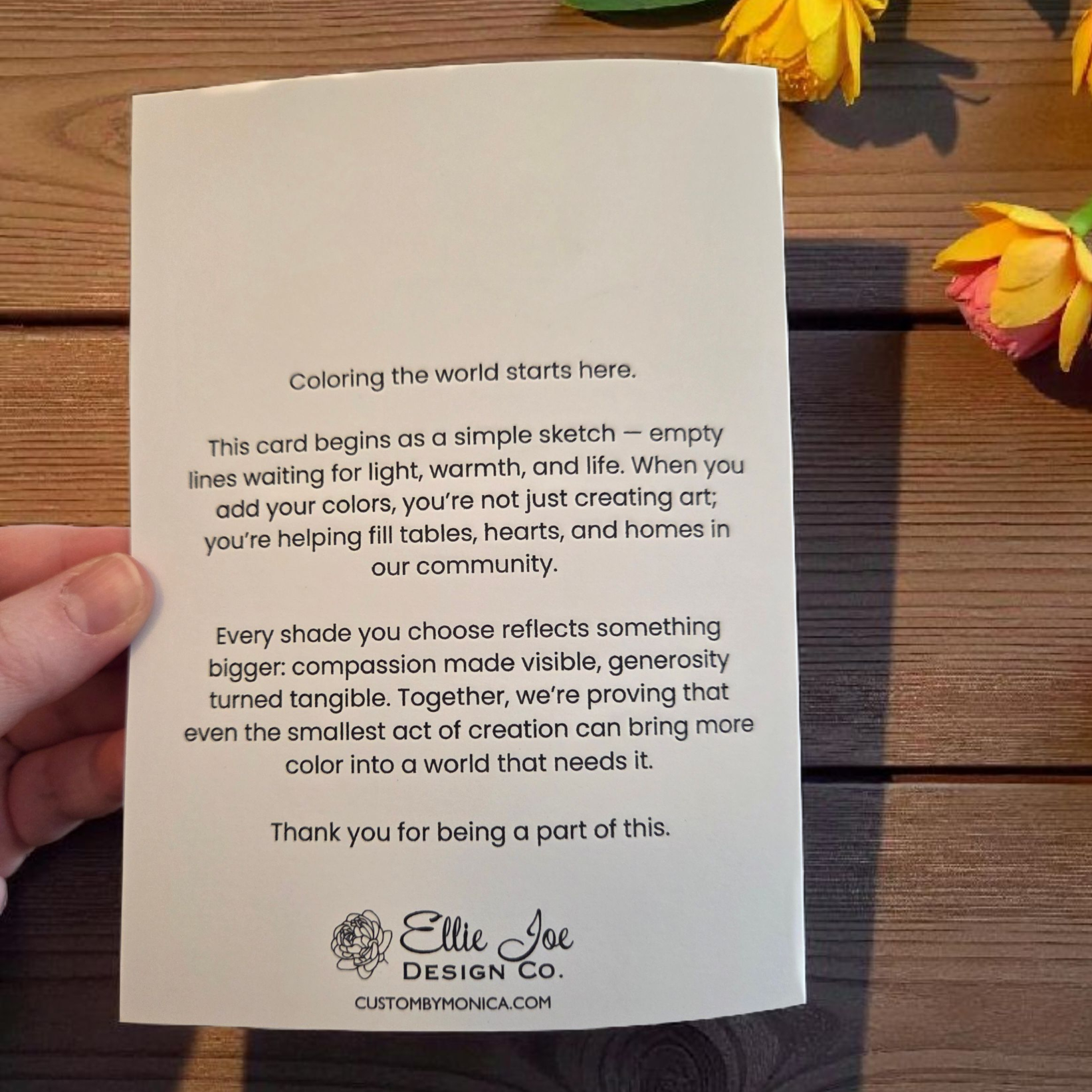 Back of greeting card featuring Ellie Joe Design Co. message about coloring the world and giving back to the local food bank.