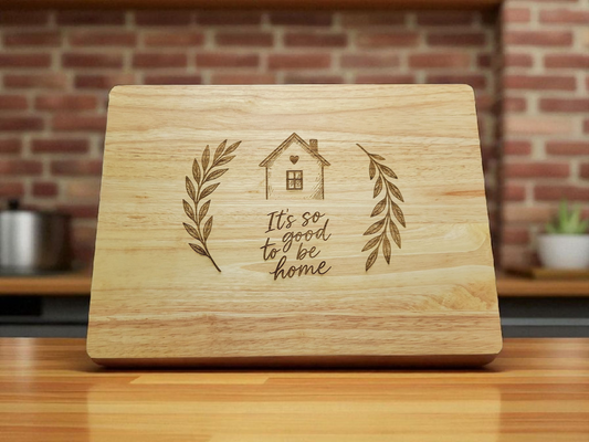 Engraved wooden cutting board with house and laurel design and the phrase It’s so good to be home – rustic farmhouse kitchen décor and gift