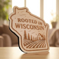 State-shaped wood magnet engraved with “Rooted in Wisconsin” and a farm scene with trees and barn.