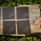 Rustic set of 4 square slate coasters, laser engraved with olive branch sprigs or a wine-and-cheese scene. Natural slate stone with etched line art design, perfect for protecting tables in style.