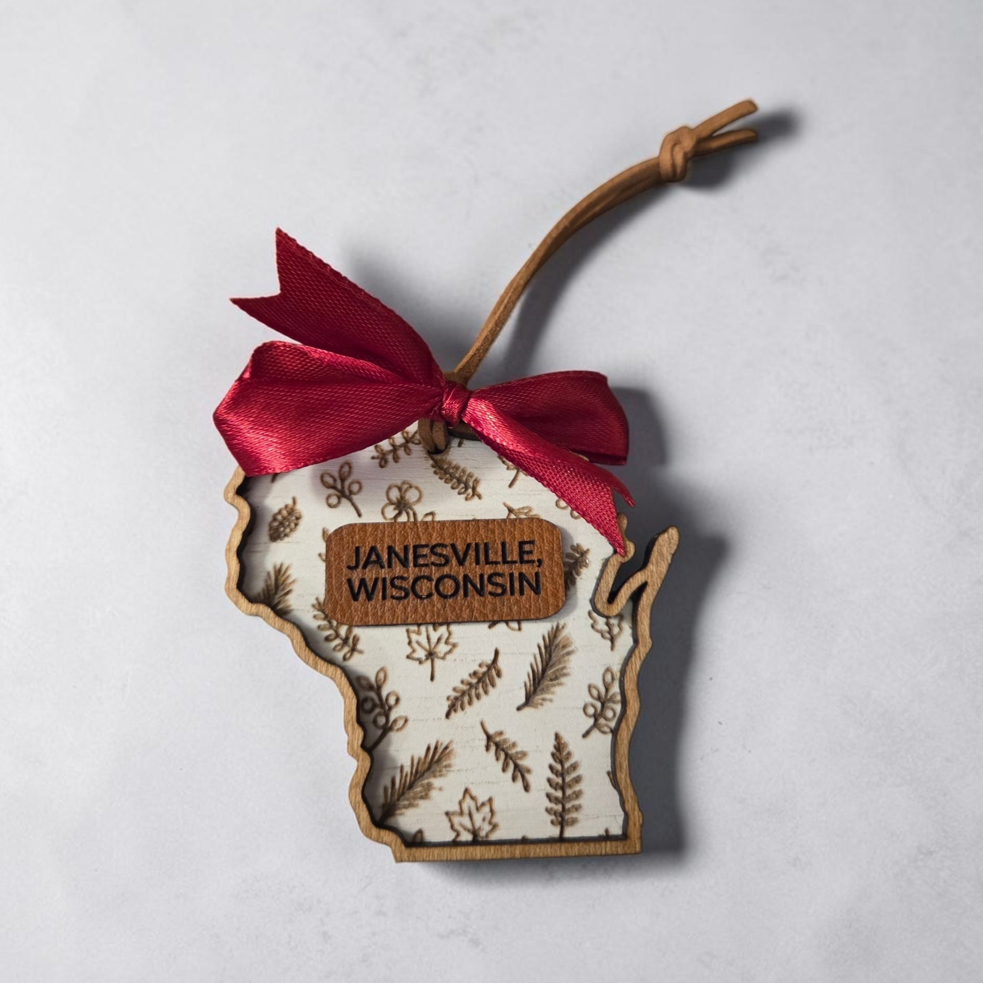 Example of a personalized Wisconsin botanical ornament featuring Janesville, Wisconsin. Buyers may choose any Wisconsin city or town for the leather personalization.