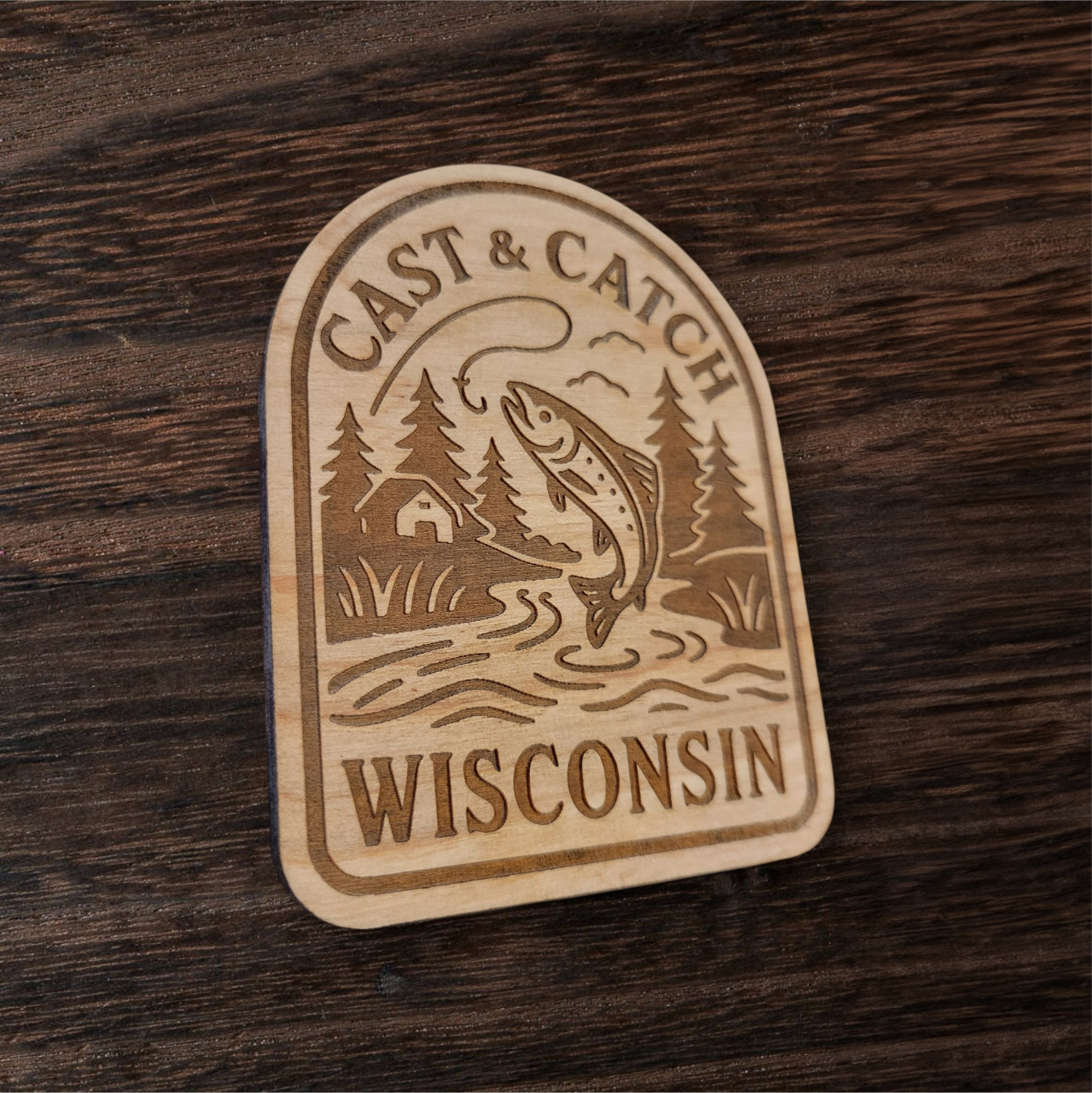 Laser engraved fishing magnet featuring a trout and cabin scene – Cast & Catch Wisconsin rustic wood design