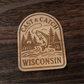 Laser engraved fishing magnet featuring a trout and cabin scene – Cast & Catch Wisconsin rustic wood design