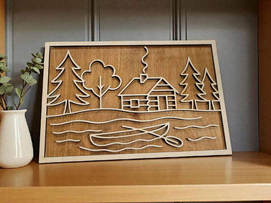 Layered wood sign featuring a rustic cabin, pine trees, and canoe scene — laser cut from multiple layers of natural wood, perfect for lake house or cabin decor.
