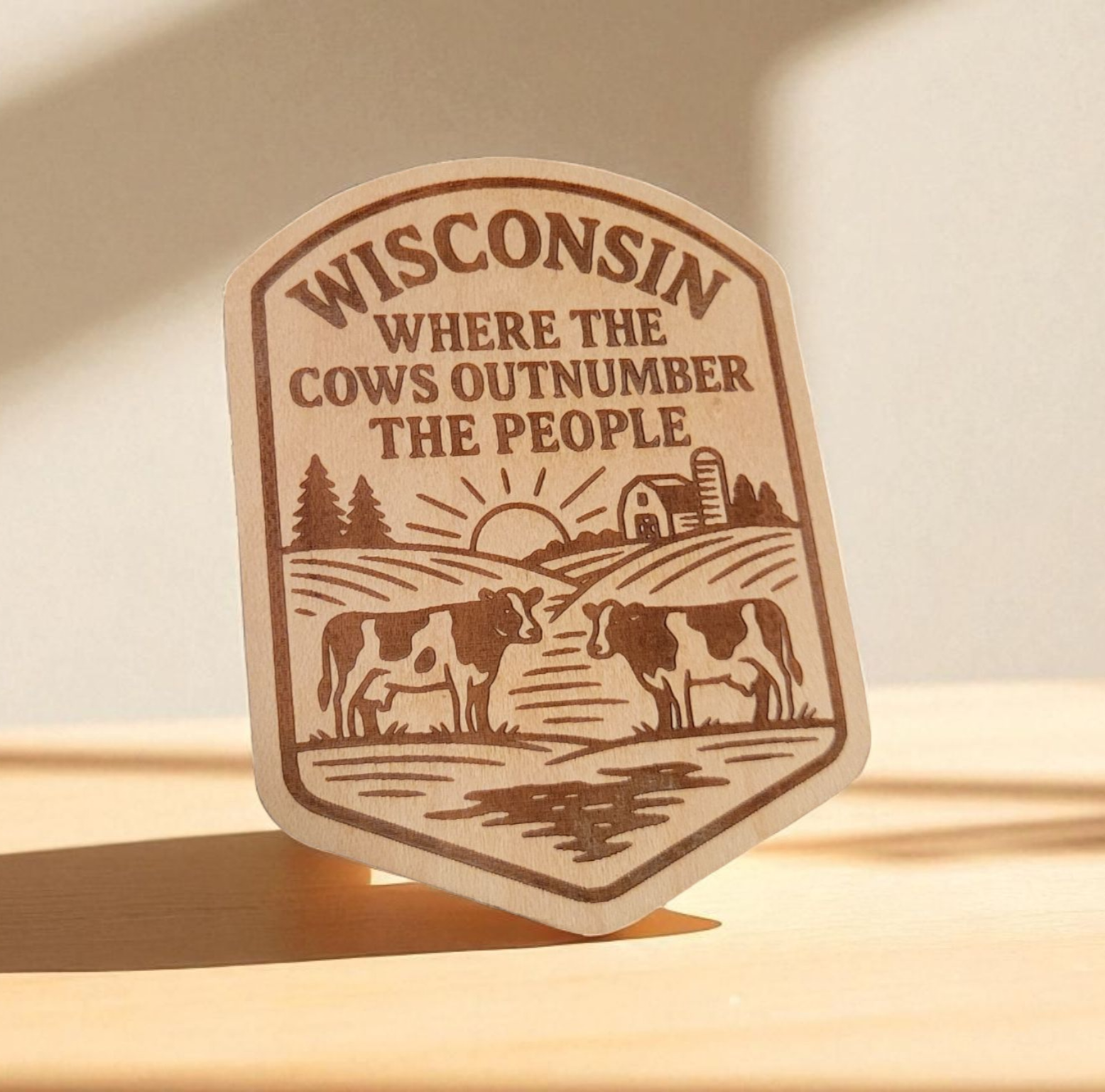Wood magnet with engraved cows, barn, and the phrase “Wisconsin: Where the Cows Outnumber the People.”