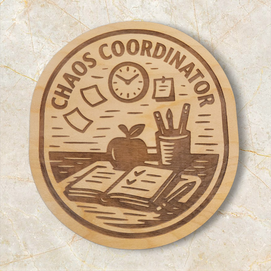 Laser engraved Chaos Coordinator wood magnet featuring teacher desk scene with open planner, apple, pencils, sticky notes, and clock