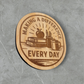 Laser engraved wood magnet with the phrase “Making a Difference Every Day” featuring an apple, books, pencils, and coffee mug