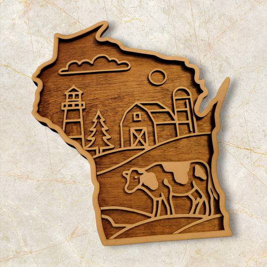 Wooden wall art in the shape of Wisconsin featuring a laser-cut farm scene with barn, lighthouse, cow, and rolling hills. Handmade decor.