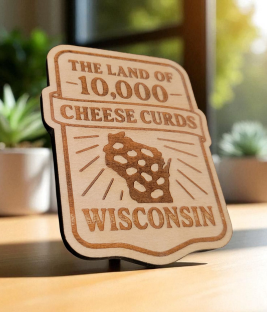 Laser-cut wooden Wisconsin magnet that reads “The Land of 10,000 Cheese Curds” with a cheese-curd-shaped state outline, styled on a badge shape.