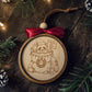 Handcrafted layered wood Christmas ornament featuring an engraved raccoon in a festively decorated trash can holding a “festive but feral” sign, finished with a wine-red bow, wood bead, and leather hanging loop.