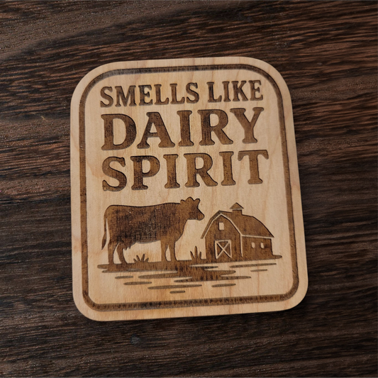 Laser-engraved wood magnet with cow and barn design, captioned “Smells Like Dairy Spirit”